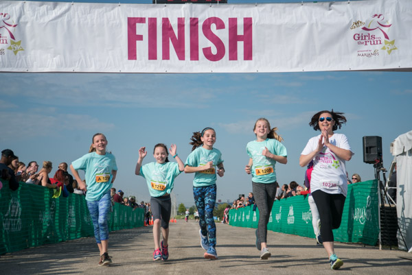 A group of girls celebrates at the finish of the Girls on the Run Chicago Southwest 5.