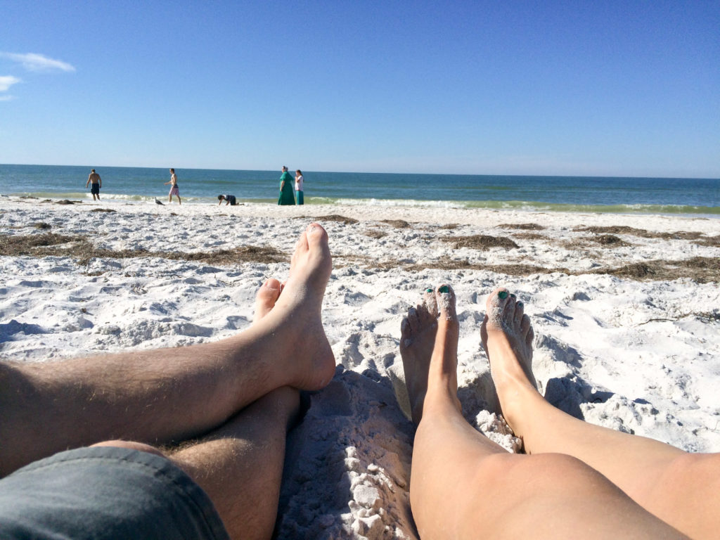 feet on the sandy beach in the sun