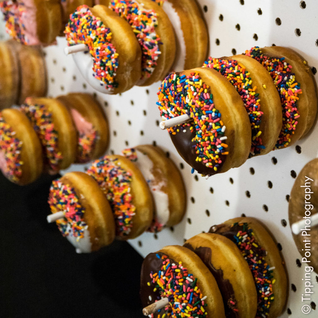 #tpptellmeastory donuts with chocolate frosting and sprinkles displayed on a donut wall